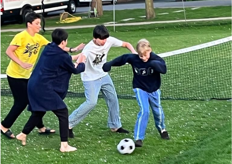 Four boys playing football in their pyjamas