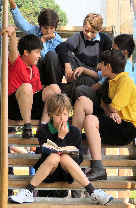 sis boys sitting on steps either reading or chatting together