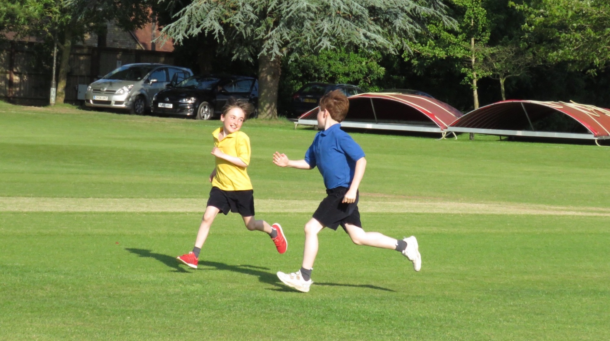 two boys running on the school field