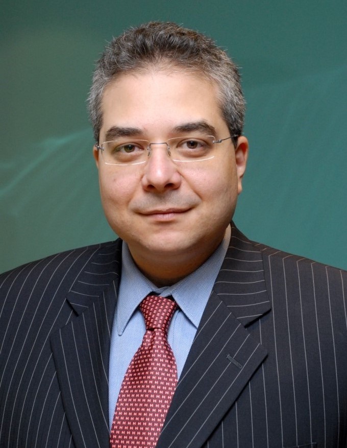 Man with grey hair and glasses wearing a suit