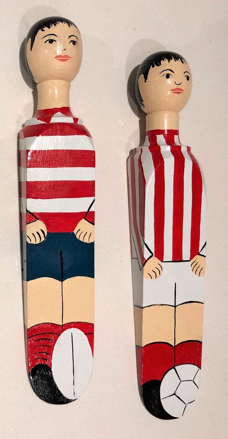 Two wooden pegs in painted as footballers