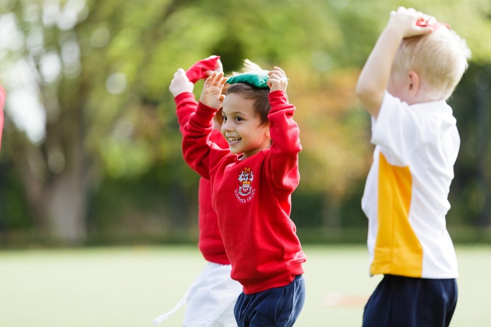 Group of three young boys looking happy  with bean bags on their heads