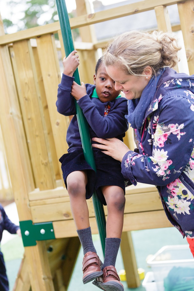 A woman assisting a child on a swing, ensuring their safety and providing guidance for a fun experience.