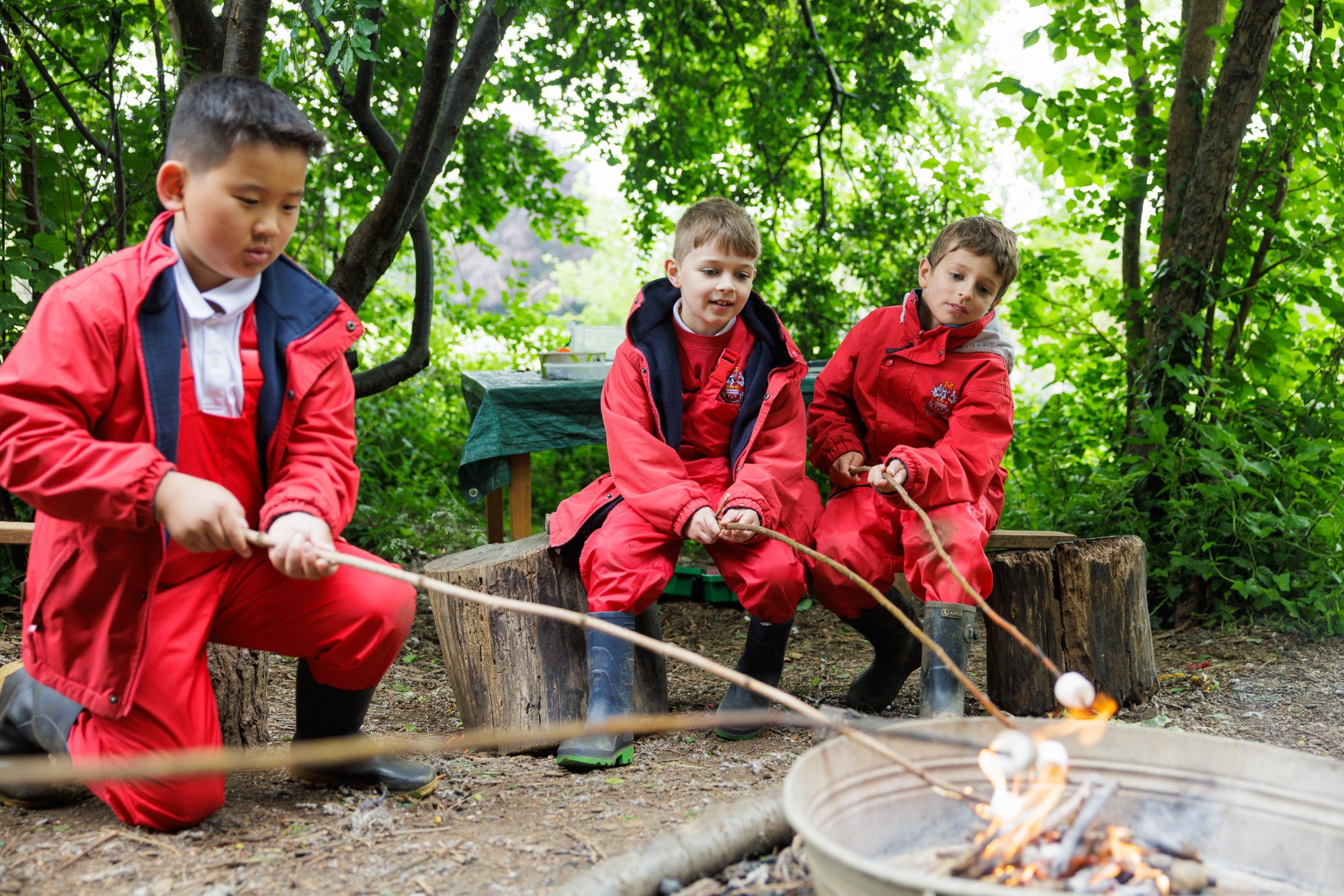 Two young boys dressing in red outdoor clothing out in nature