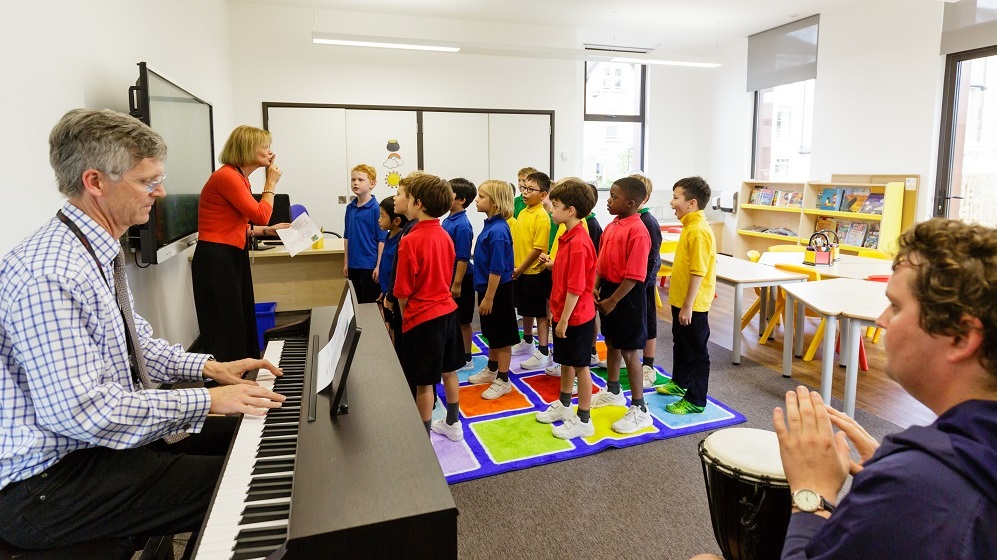 A classroom filled with children joyfully playing musical instruments together.