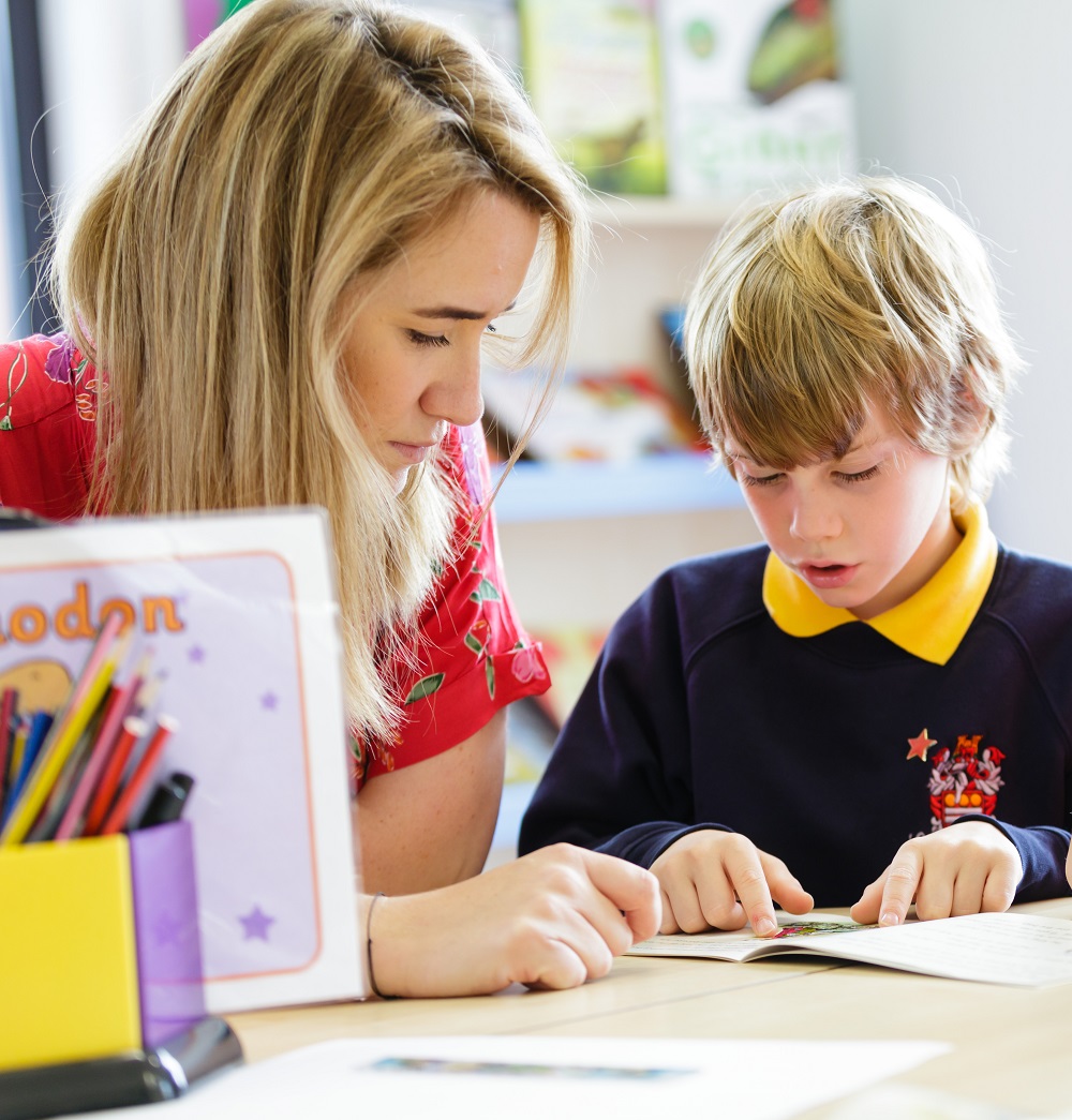 A woman with a child in a classroom collaborating on a project