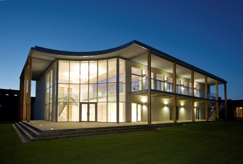 Large glass fronted building with steps leading up to it and balcony running around it